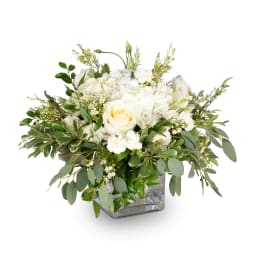 White roses and mixed white flowers in a square glass vase