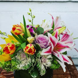 Mixed bouquet with pink lilies, tulips, and purple cabbage in a black box