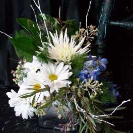 Bouquet of white daisies and blue flowers with greenery