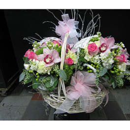 Pink and white floral basket arrangement with ribbon bows