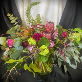 Mixed bouquet with pink protea and eucalyptus in a glass vase