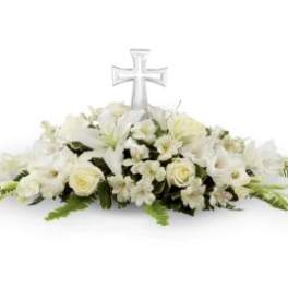 White floral casket spray with a clear cross centerpiece