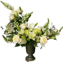 White floral arrangement in a dark urn vase
