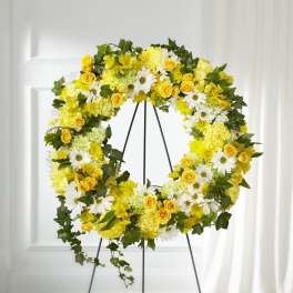 Yellow and white floral wreath on a black stand