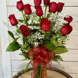Bouquet of red roses with baby's breath in a glass vase