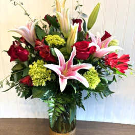 Bouquet of red roses and pink lilies in a gold vase