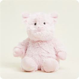 Pink plush pig toy sitting against a plain background