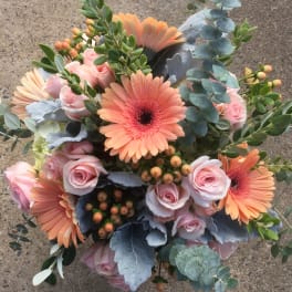 Bouquet of pink roses and peach gerbera daisies with eucalyptus