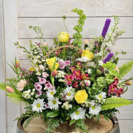Mixed flower basket with yellow roses, daisies, and pink blooms
