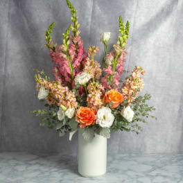 Mixed bouquet in a white vase with orange and white blooms