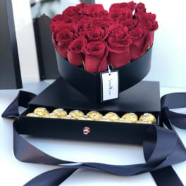 Red roses in a black box with gold chocolates in a drawer