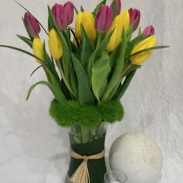 Bouquet of yellow and purple tulips in a glass vase