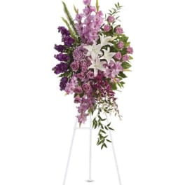 Tall purple and white floral standing spray on a white easel