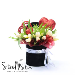 Tulip arrangement in a black hat box with red glitter hearts