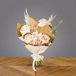 Bouquet of pale pink roses with dried grasses and cream wrapping