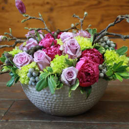 Lavender roses and pink blooms in a textured bowl vase