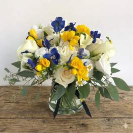 Blue, yellow, and white bouquet in a glass vase
