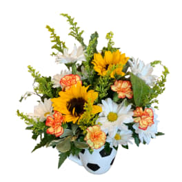 Bouquet of sunflowers, daisies, and carnations in a soccer ball vase