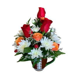 Red roses and white daisies in a football-shaped mug