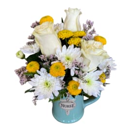 White roses and yellow daisies in a blue nurse mug