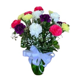 Bouquet of colorful carnations in a green vase with a blue ribbon