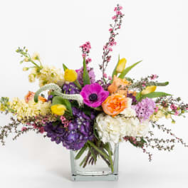 Colorful mixed flower arrangement in a clear glass vase
