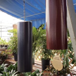 Hanging metal wind chimes above potted houseplants