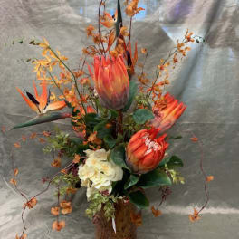 Orange tropical flowers arranged in a glass vase
