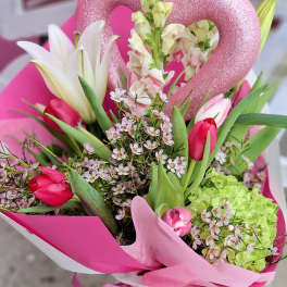 Pink tulips and white lilies in a bright bouquet with a glittery heart pick