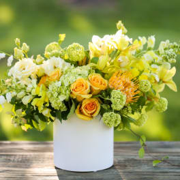 Yellow and white floral arrangement in a white vase