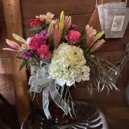 Bouquet of pink lilies and hydrangeas with a white ribbon