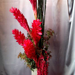Tall arrangement of red tropical flowers in a rectangular vase