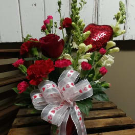 Red roses and carnations with a heart-patterned ribbon bow