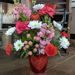 Pink and white flowers in a red glitter heart vase