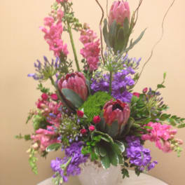 Tall mixed bouquet with pink and purple flowers in a white vase