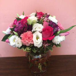 Mixed pink, white, and purple bouquet in a glass vase