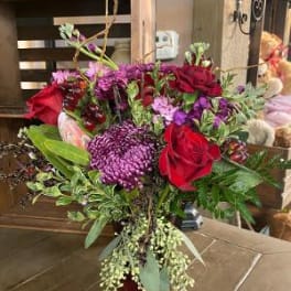 Bouquet of red and purple flowers in a dark vase