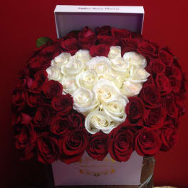 Heart-shaped arrangement of red and white roses in a white box