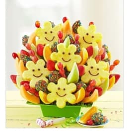Fruit bouquet with smiling pineapple flowers in a green container