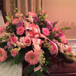 Pink floral casket spray with roses, lilies, and gerbera daisies