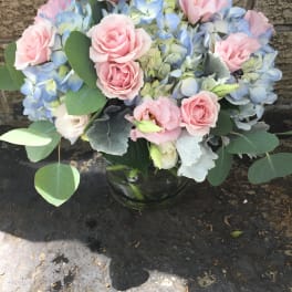 Pink roses and blue hydrangeas in a glass vase