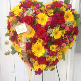 Heart-shaped bouquet of red roses and yellow daisies on a stand