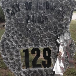 Large silver floral tribute with "City of Hoboken Police" and "129" lettering
