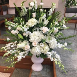 Large white floral arrangement in a pale vase
