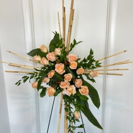 Peach rose arrangement on a bamboo stand with trailing greenery