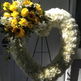 Heart-shaped floral wreath with yellow roses and white flowers