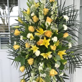 Large standing spray of yellow roses and lilies with white accents