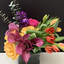 Bouquet of roses, calla lilies, and tulips in a glass vase