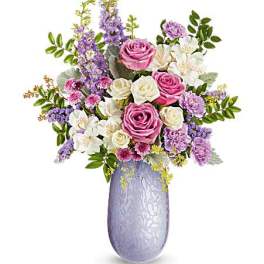 Pink and white roses with purple flowers in a lavender vase