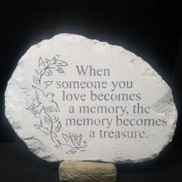 Memorial stone with engraved quote and dove design on a stand